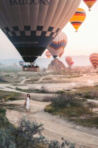 Hot air balloons soar above Cappadocia's unique landscape during a stunning sunrise.